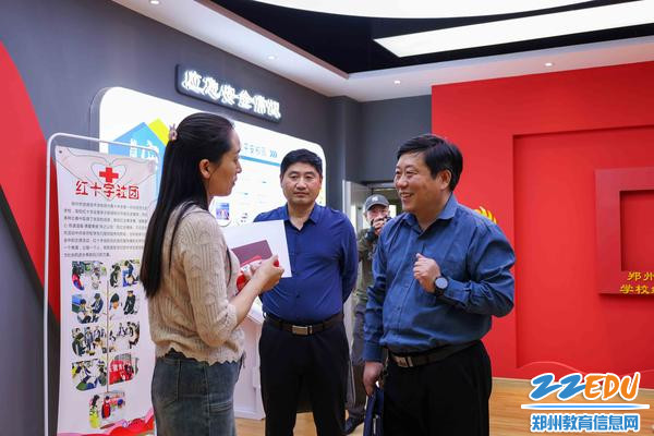 4郑州市信息技术学校团委书记李晓培向客人介绍社团建设情况